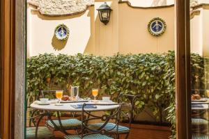 佛罗伦萨Guest House Morandi的天井上配有带2把椅子的桌子和饮品