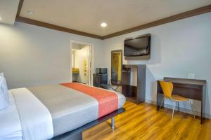 加迪纳市加迪纳6汽车旅馆的一间卧室配有一张床、一张书桌和一台电视。