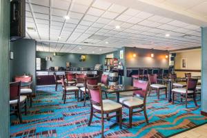 新费城荷兰山谷贝斯特韦斯特酒店的餐厅铺有色彩缤纷的地毯,配有桌椅