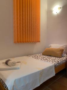 弗尔尼亚奇卡矿泉镇Apartman Vrnjačka Banja的一间小卧室,配有一张带橙色窗户的床