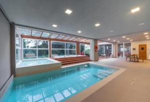 格拉玛多Hotel Laghetto Stilo Borges的一座大游泳池,位于一座房子内,设有浴缸