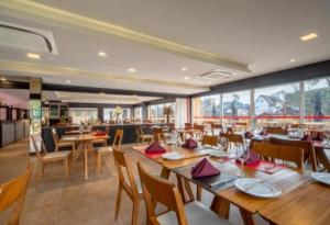 格拉玛多Hotel Laghetto Stilo Borges的一间带木桌椅的用餐室和一间餐厅