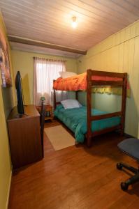 特木科Hostal Sol Temuco的一间卧室配有双层床和电视。