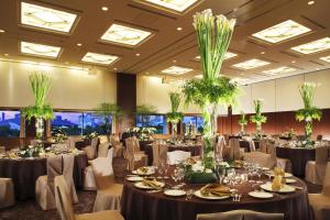 东京东京湾有明华盛顿酒店的宴会厅配有桌椅和植物