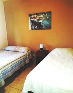 圣佩德罗苏拉Hermoso Apartamento的一间卧室设有两张床,墙上挂着一幅画