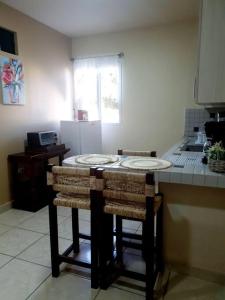 圣佩德罗苏拉Hermoso Apartamento的厨房配有带2把吧台凳的吧台