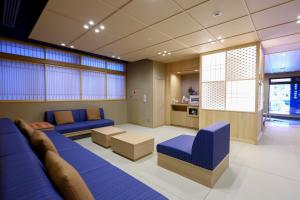 仙台Onyado Nono Sendai Natural Hot Spring的客厅配有蓝色的沙发和桌子