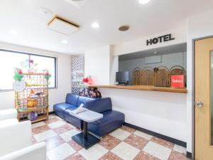 宫崎Tabist Rays Hotel Suisen的一间设有蓝色椅子和桌子的酒店等候室