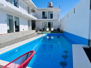 伊察La Estancia Hotel Ica的一个带两把椅子的游泳池以及一座房子