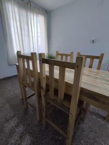 圣米格尔·德·图库玛Casa Barrio Sur COMODA的一张木桌和两把椅子坐在窗边