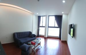 土龙木市Khang Điền Hotel的客厅配有沙发和桌子