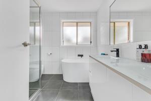 伊丘卡Sleepy Shackell - Echuca Moama Holiday Accommodation的白色的浴室设有浴缸和水槽。