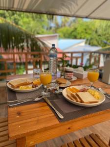 弗里德胡Bougainvillea Inn - Maldives的一张桌子,上面放着两盘食物和两杯橙汁