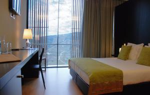 拉梅戈昆塔德卡萨勒德龙霍葡萄酒酒店的配有一张床、一张书桌和一扇窗户的酒店客房