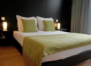 拉梅戈昆塔德卡萨勒德龙霍葡萄酒酒店的一张大床,位于酒店带两盏灯的房间