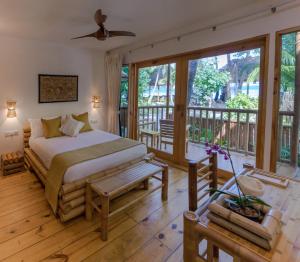 ThinadhooEcoboo Maldives的一间卧室设有一张床和一个阳台
