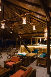 ThinadhooEcoboo Maldives的大型客房配有桌椅和灯具。