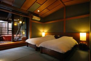 箱根Hakone Fontaine Bleau Sengokutei的一间卧室配有一张带白色床单的床和一扇窗户。