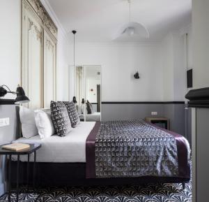 巴黎马尔特阿斯托特尔酒店的一间卧室配有一张大床和枕头