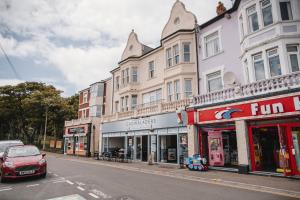 巴里Barry Island Beachfront Apartment - Stunning Bay Views and Private Parking的城市街道上一排有汽车的建筑物