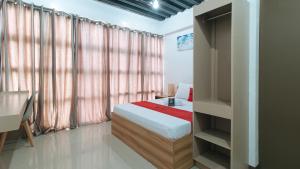 伊洛伊洛RedDoorz Near Iloilo International Airport的一间卧室设有一张床和一个书架