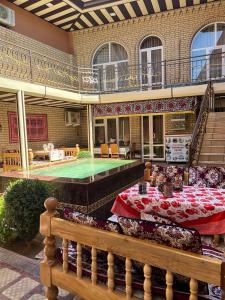 撒马尔罕SHAHNOZA GRAND的一个带桌子和游泳池的庭院