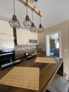 新瓦罗什Apartman Zara Zlatar的一间厨房和带大木桌的客厅