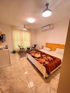 阿尔哈德السكون لبيوت الضيافة و شاليه AL Sukun For Guest Houses & Chalet的一间卧室配有一张大床和一张桌子及椅子