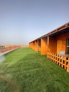 阿尔哈德السكون لبيوت الضيافة و شاليه AL Sukun For Guest Houses & Chalet的一座有大院子的绿色草的建筑
