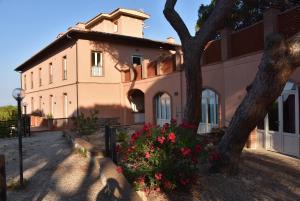 里奥马里纳Allegroitalia Elba Capo d'Arco的前面有棵树和鲜花的房子