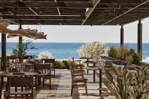 罗德岛卡利地亚Elissa Adults-Only Lifestyle Beach Resort的餐厅设有桌椅,以大海为背景
