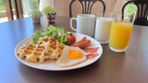 白马村白马第七天堂酒店的包括华夫饼、沙拉和橙汁的早餐食品