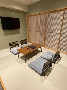 京都Sakura Cross Hotel Kyoto Kiyomizu的客厅配有两把椅子和一张桌子