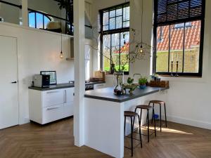 PeinsKerkje van Peins的一间厨房,配有白色橱柜和一个带酒吧凳的岛屿