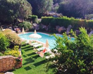 阿比亚多利green park cala di volpe的一个带躺椅和遮阳伞的游泳池