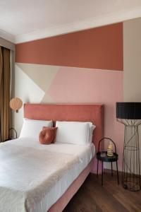 罗马加拉提精品酒店 的卧室配有白色床和红色床头板