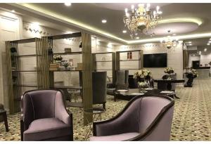 锡利夫里Westport Istanbul Resort & Spa Hotel的沙龙设有紫色的桌椅和吊灯