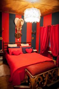 瓦雷泽奥兹共和国客房旅馆的卧室配有红色的床,墙上挂着一只猫