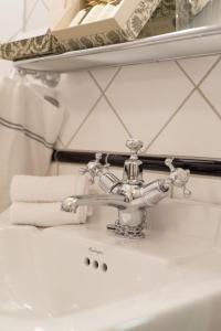 达伦达伦酒店的浴室水槽配有银色水龙头和毛巾