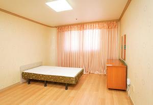 横城Koresco Chiak Mountain Condominium的一间卧室配有床、窗户和梳妆台