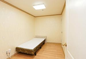 横城Koresco Chiak Mountain Condominium的一间位于客房角落的带一张床的房间