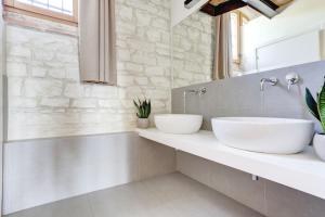 锡罗洛Villa Vetta Marina - My Extra Home的浴室设有石墙和2个水槽。
