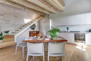 锡罗洛Villa Vetta Marina - My Extra Home的厨房以及带木桌和椅子的用餐室。