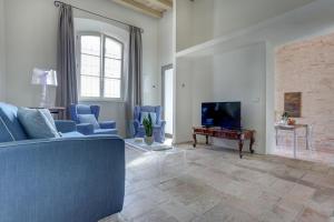 锡罗洛Villa Vetta Marina - My Extra Home的客厅配有蓝色的沙发和电视
