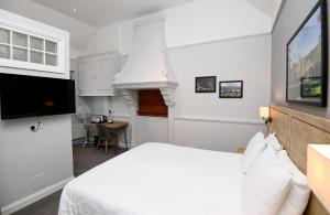 布里斯托Fox & Goose, Barrow Gurney by Marston's Inns的一间白色卧室,配有床和电视
