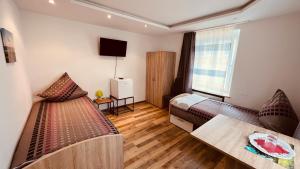 阿尔戈伊地区伊斯尼Sehr zentrales und modernes Zimmer in Isny im Allgäu mit Gemeinschaftsbad的酒店客房设有两张床和一张桌子。
