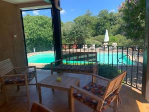维琪奥港Villa dans un cadre verdoyant , piscine et jardin的一个带桌椅的庭院和一个游泳池