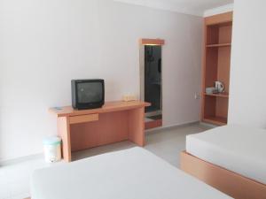 丹戎槟榔彩虹度假酒店的客房设有两张床和一张书桌上的电视