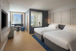 曼谷Miracle Grand Convention Hotel的酒店客房设有两张床和电视。