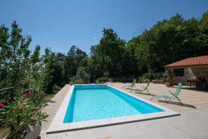 奥帕提亚Villa Kruno, with the pool and spectacular sea view的庭院内的游泳池,带椅子和树木